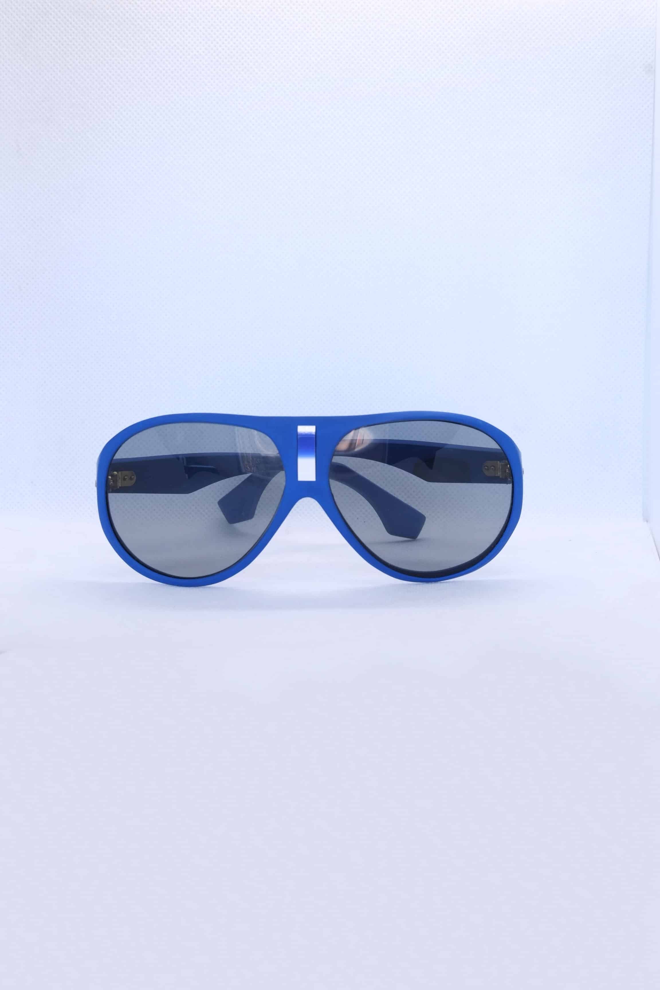 Front view of vintage 1970s SKILOOK matte cobalt blue shield-style alpine sunglasses with a silver metallic nose bridge accent and gray lenses against a white backdrop.