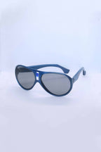Angled view of vintage 1970s SKILOOK metallic blue shield-style alpine sunglasses with a silver metallic nose bridge accent and gray lenses against a white backdrop.