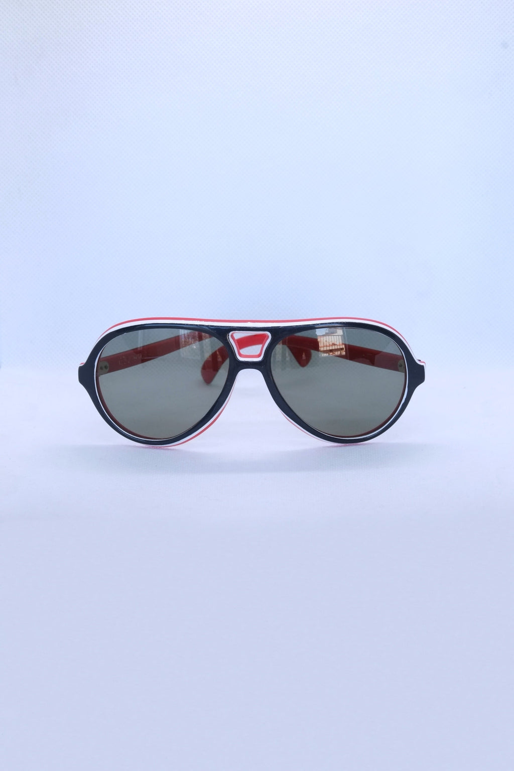 Front view of vintage 1970s SKILOOK tricolor drop aviator sunglasses with a navy blue frame, red inner rim, white pinstripe accents, and dark grey lenses.