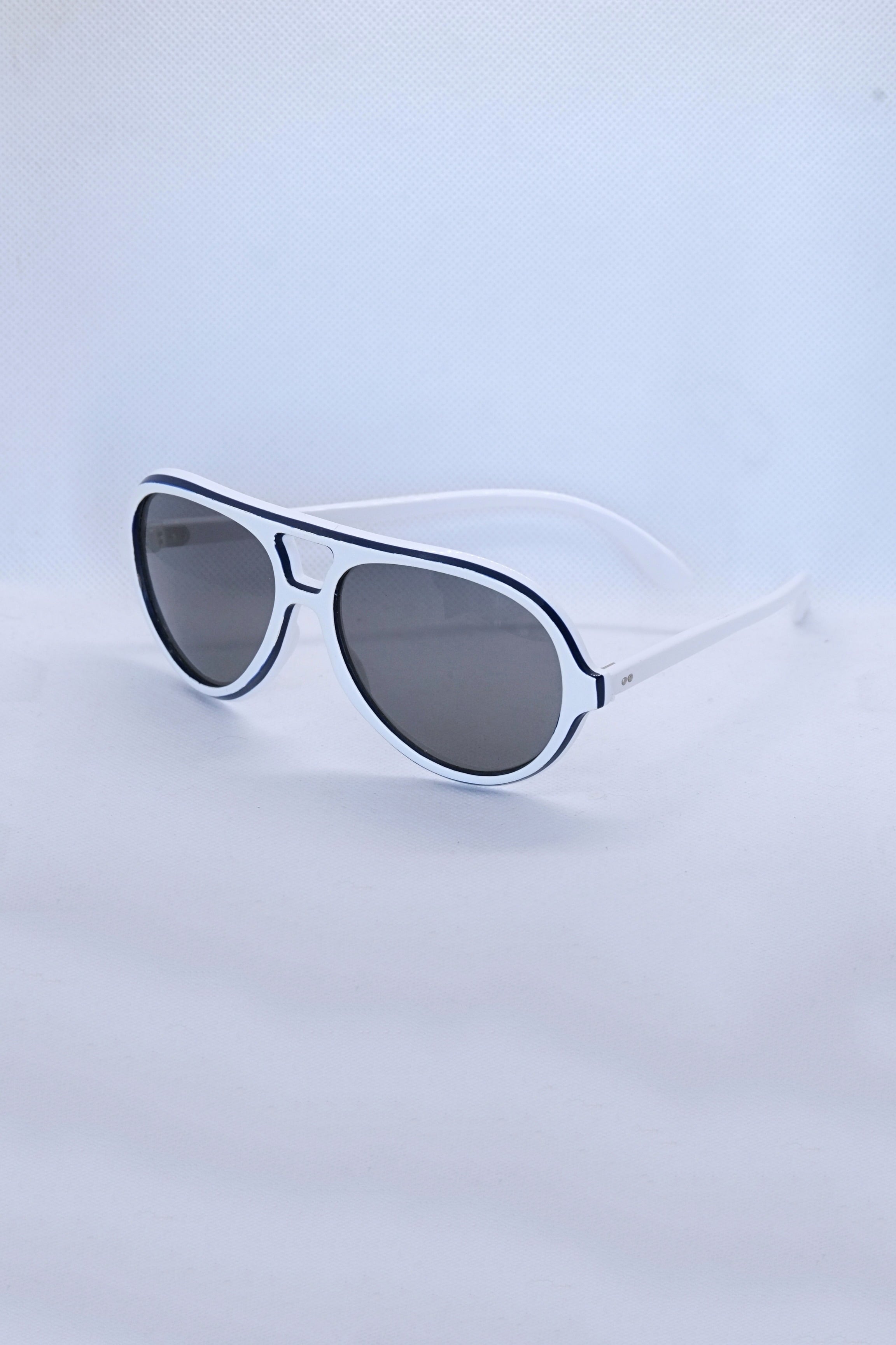 Angled view of vintage 1970s SKILOOK tricolor drop aviator sunglasses featuring a crisp white acetate frame with navy blue outer trim and dark gray lenses.