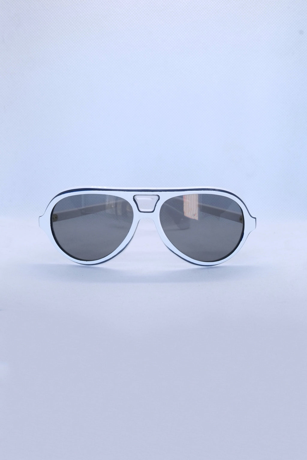 Front view of vintage 1970s SKILOOK tricolor drop aviator sunglasses featuring a crisp white acetate frame with navy blue outer trim and dark gray lenses.