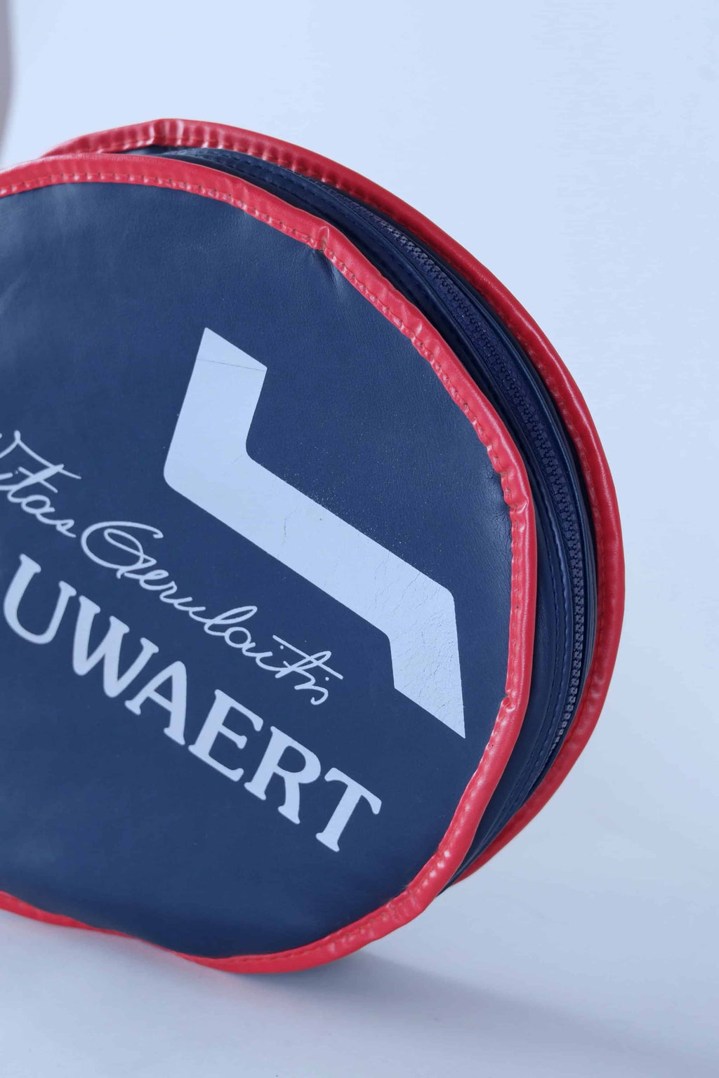 Close-up shot of the textured white vinyl material and vibrant blue and red graphics on the vintage Snauwaert racquet cover.