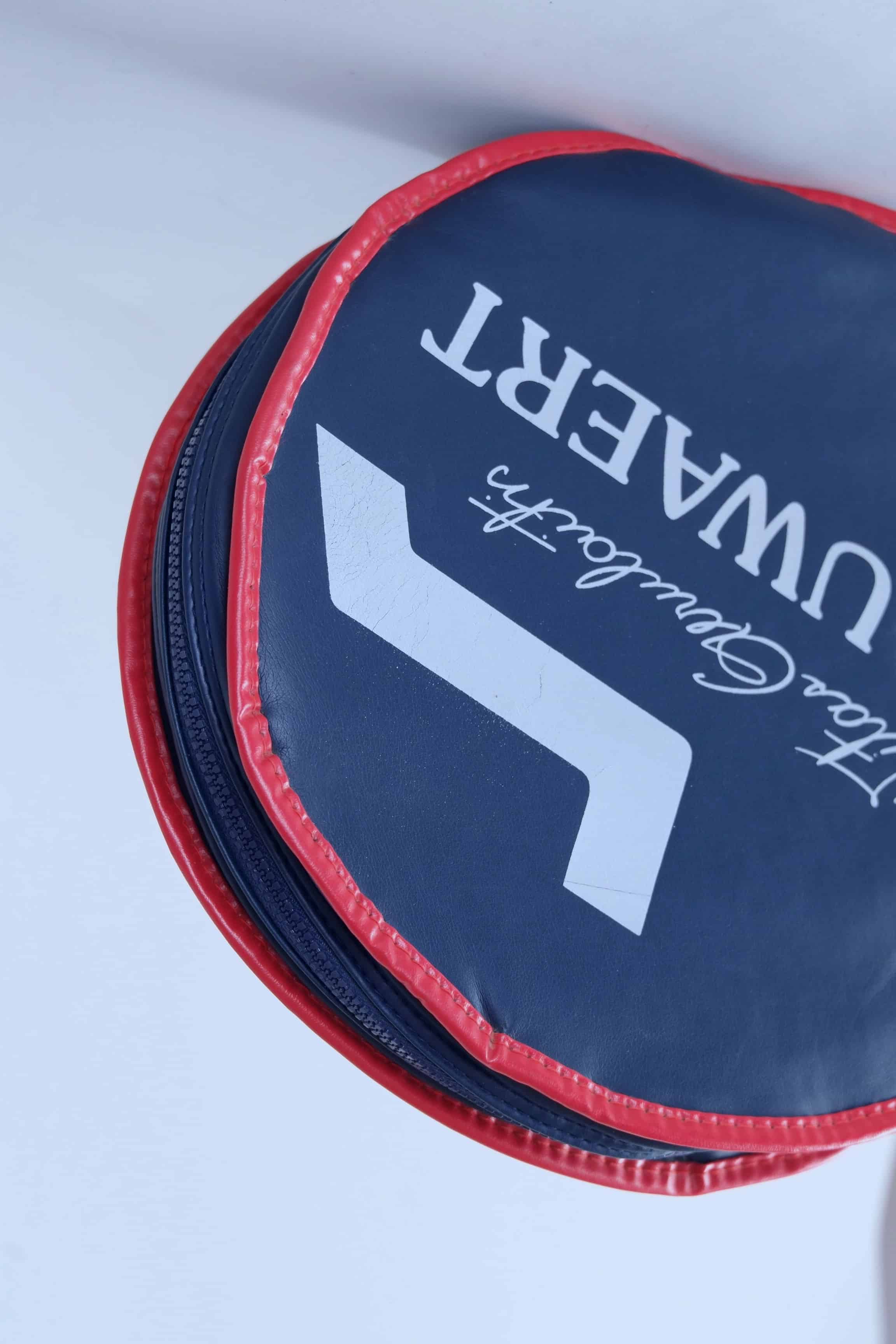 Close-up shot of the textured white vinyl material and vibrant blue and red graphics on the vintage Snauwaert racquet cover.