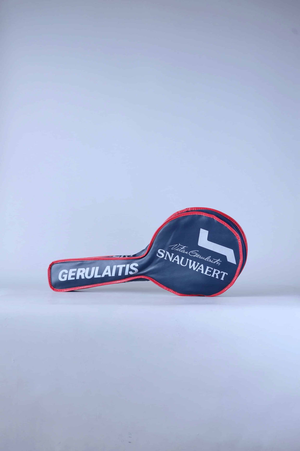 Full view of a white vintage 1980s Snauwaert Vitas Gerulaitis signature tennis racquet zippered head cover with blue and red stripe details.