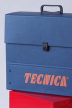 Detail shot showing corner of the Tecnica case with rivets and part of the orange logo.