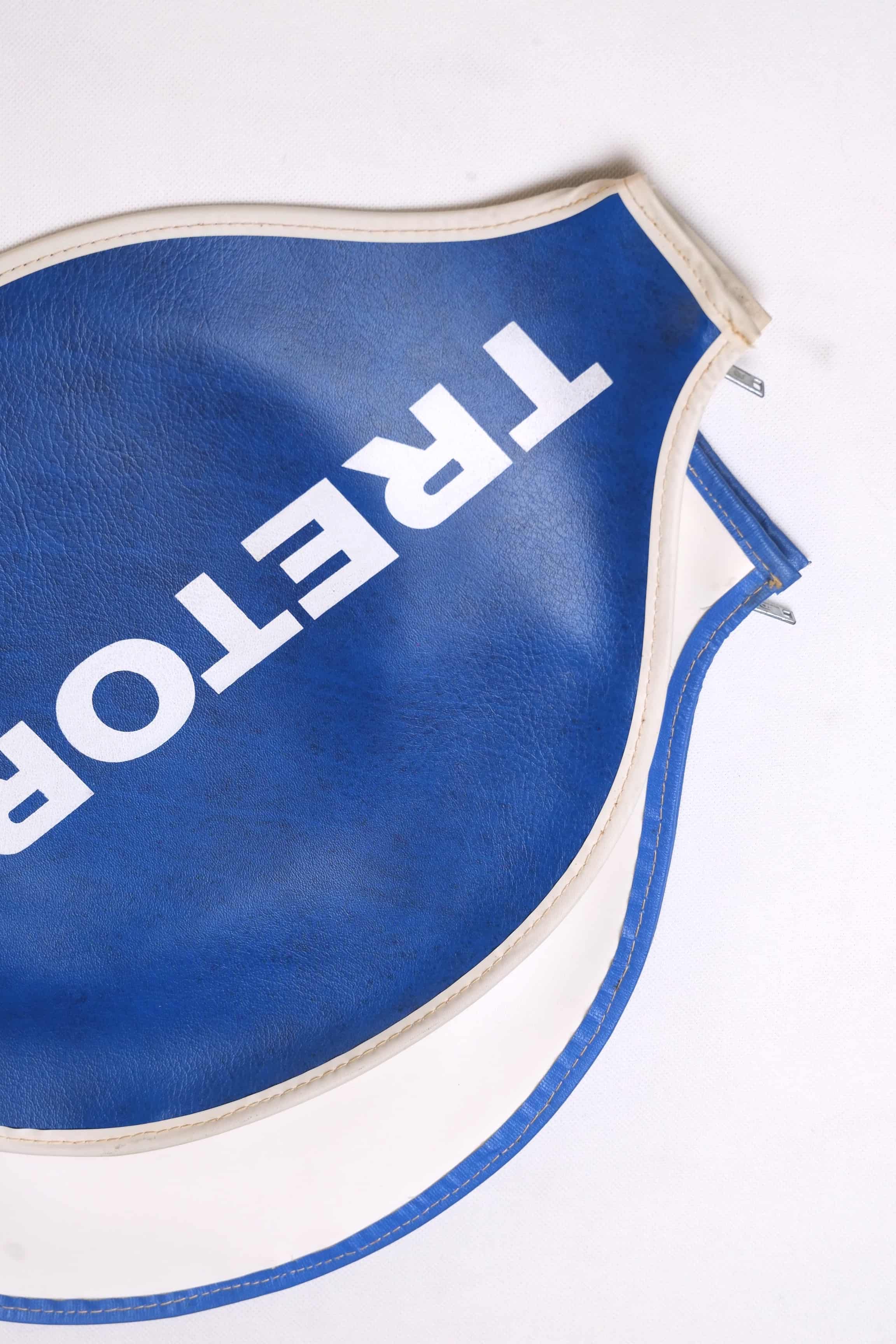 Close-up cropped view of two fanned-out vintage Tretorn vinyl racket covers in white and royal blue, emphasizing the stitched border detail.