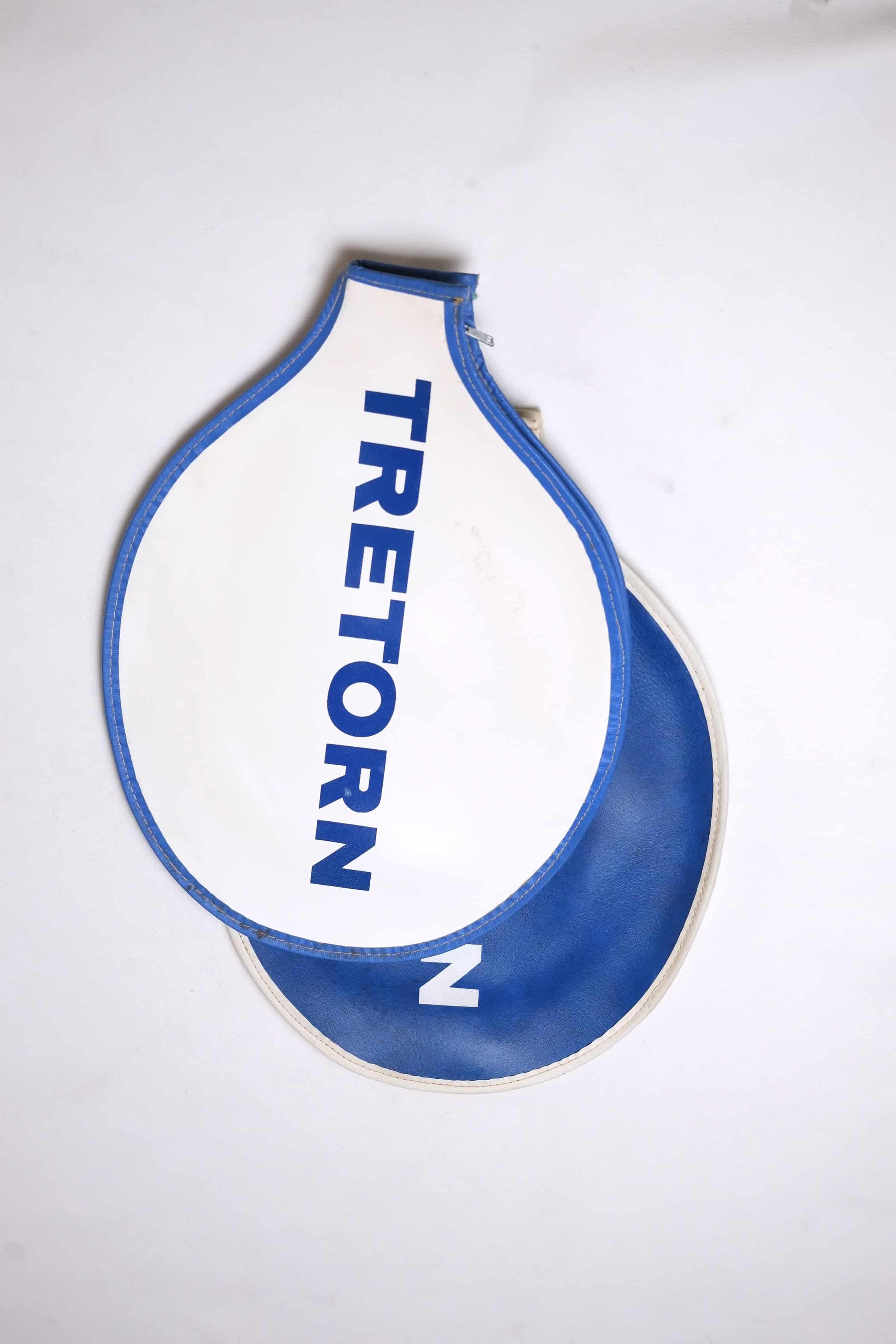 Two vintage Tretorn vinyl tennis racket covers stacked together: a top white cover with blue trim and vertical text, and a bottom blue cover with white trim.