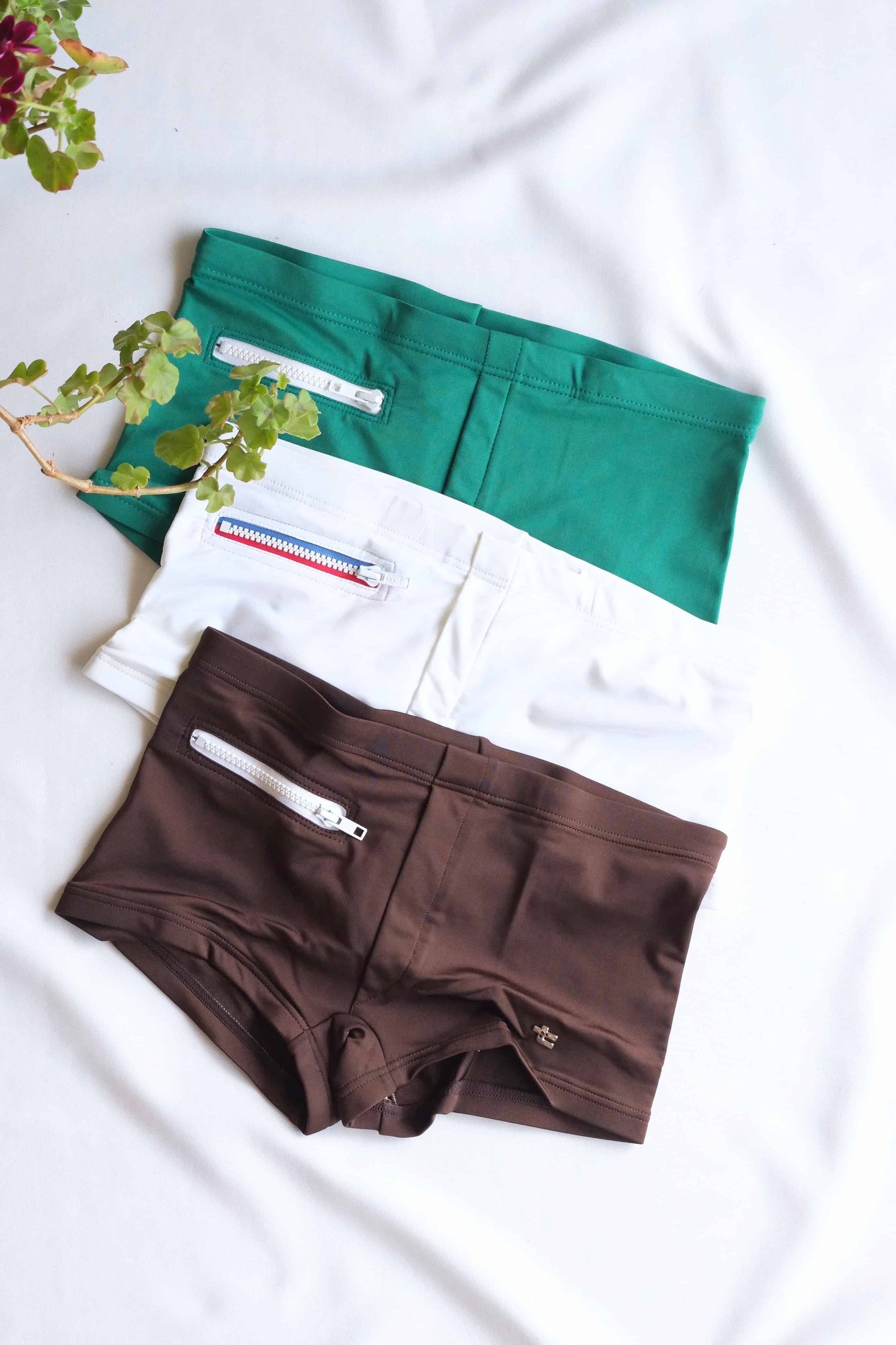 Green, White and Brown Vintage 70's Swim Briefs with Pocket laid on white background