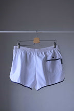 TROPIC Vintage Men's White Shorts displayed on a hanger, viewed from the backside, showing an elastic waistband and a back pocket with navy blue trim.