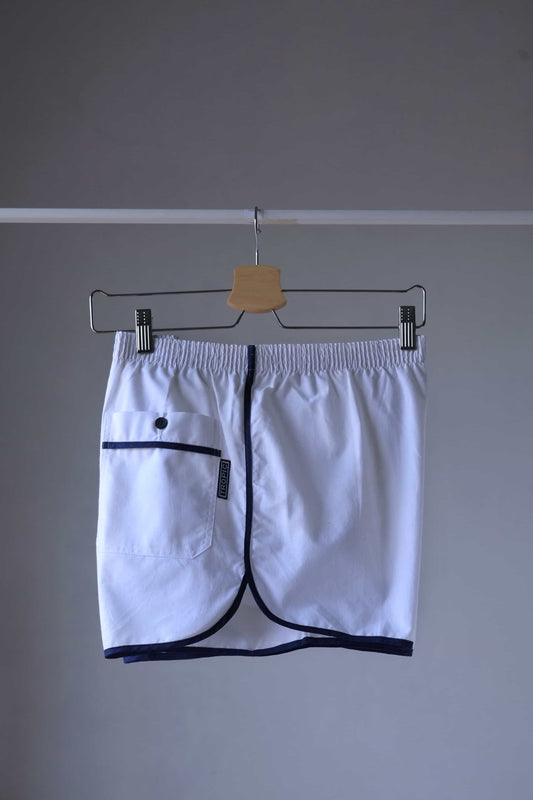 TROPIC Vintage Men's White Shorts on a hanger, viewed from the right side, highlighting the pocket and side trim detail