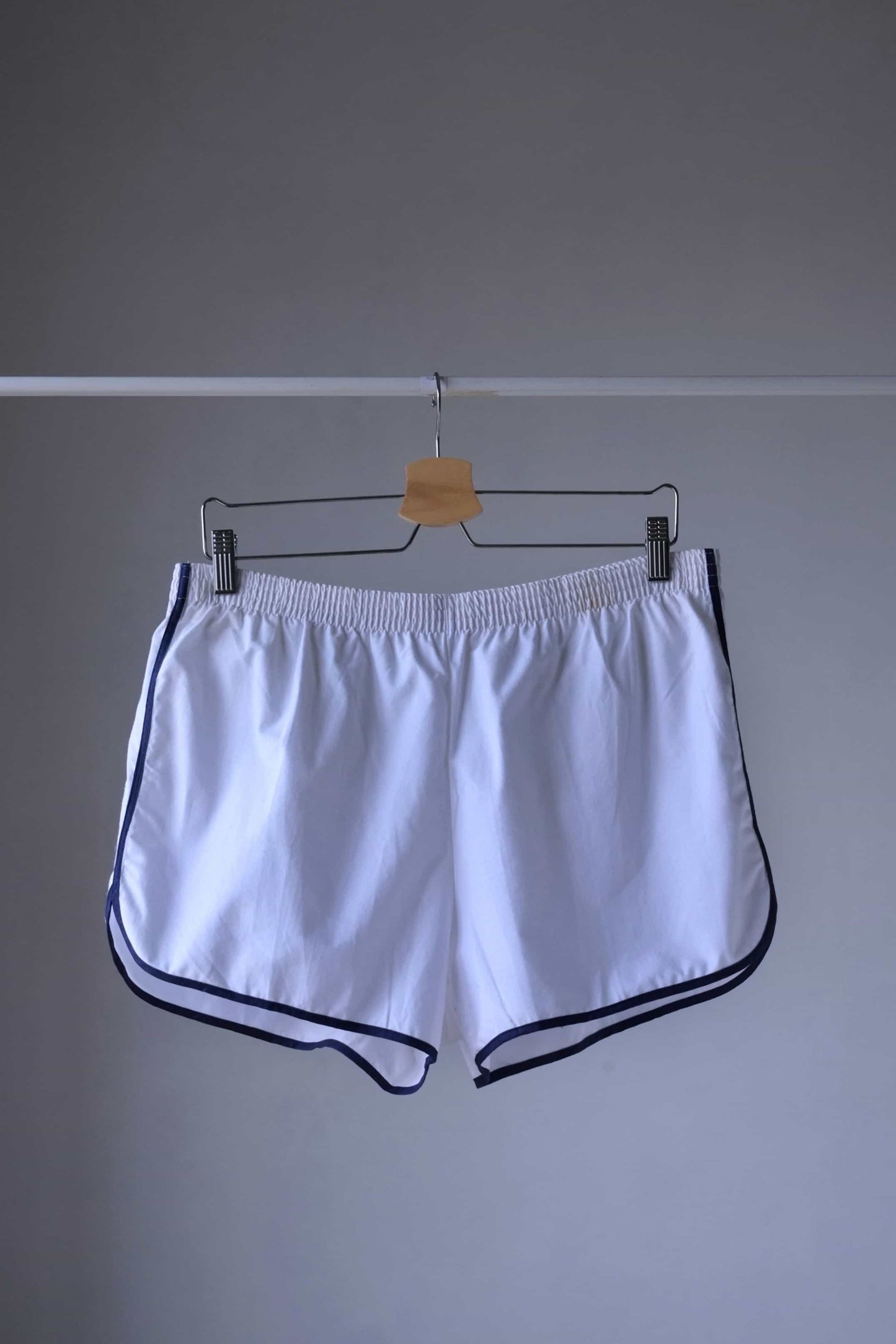 TROPIC Vintage Men's White Shorts displayed on a hanger, viewed from the front, showing an elastic waistband with navy blue trim