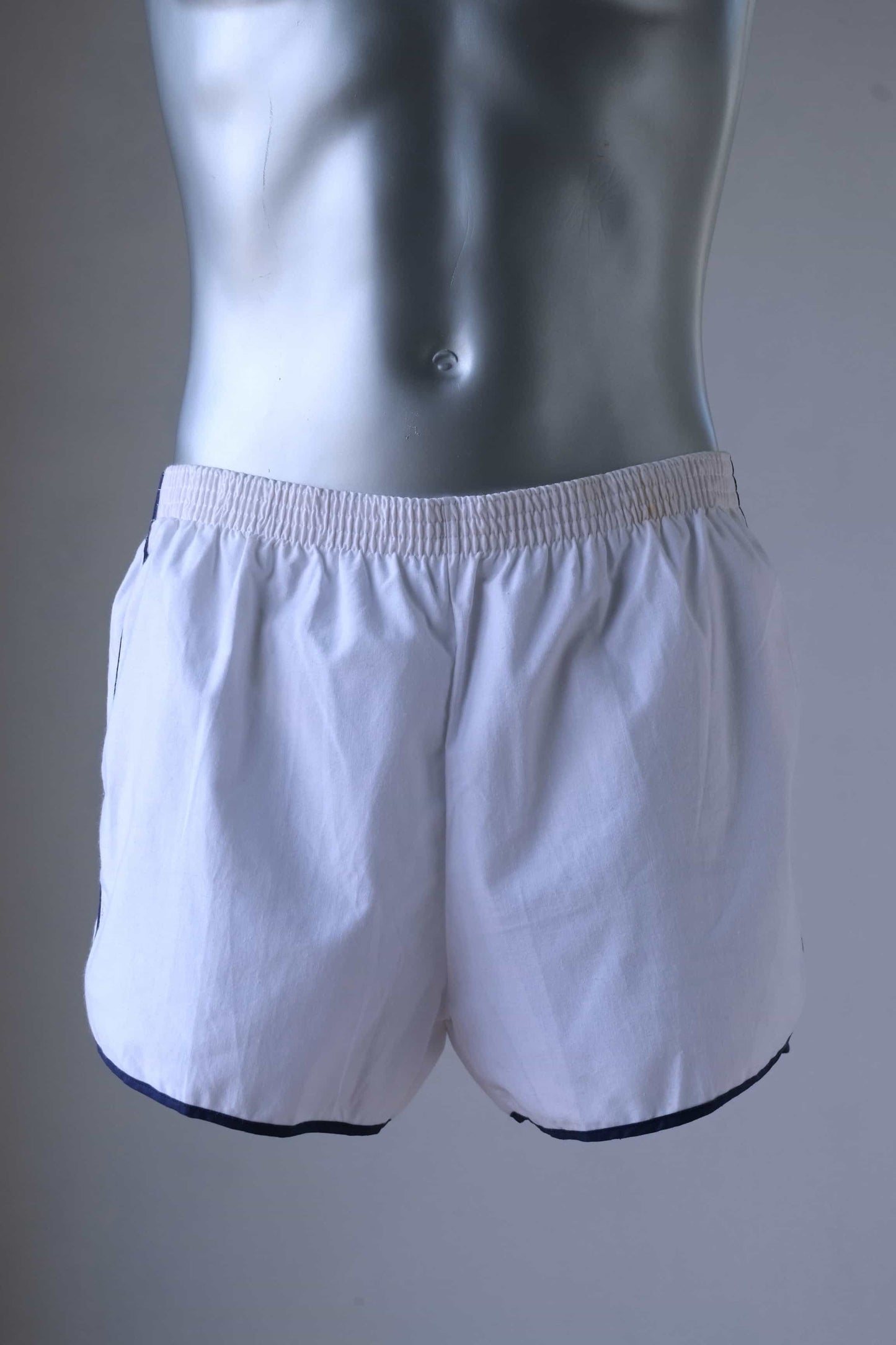 TROPIC Vintage Men's White Shorts worn on a mannequin, front view showing the shorts' fit and detailing on a metallic torso.