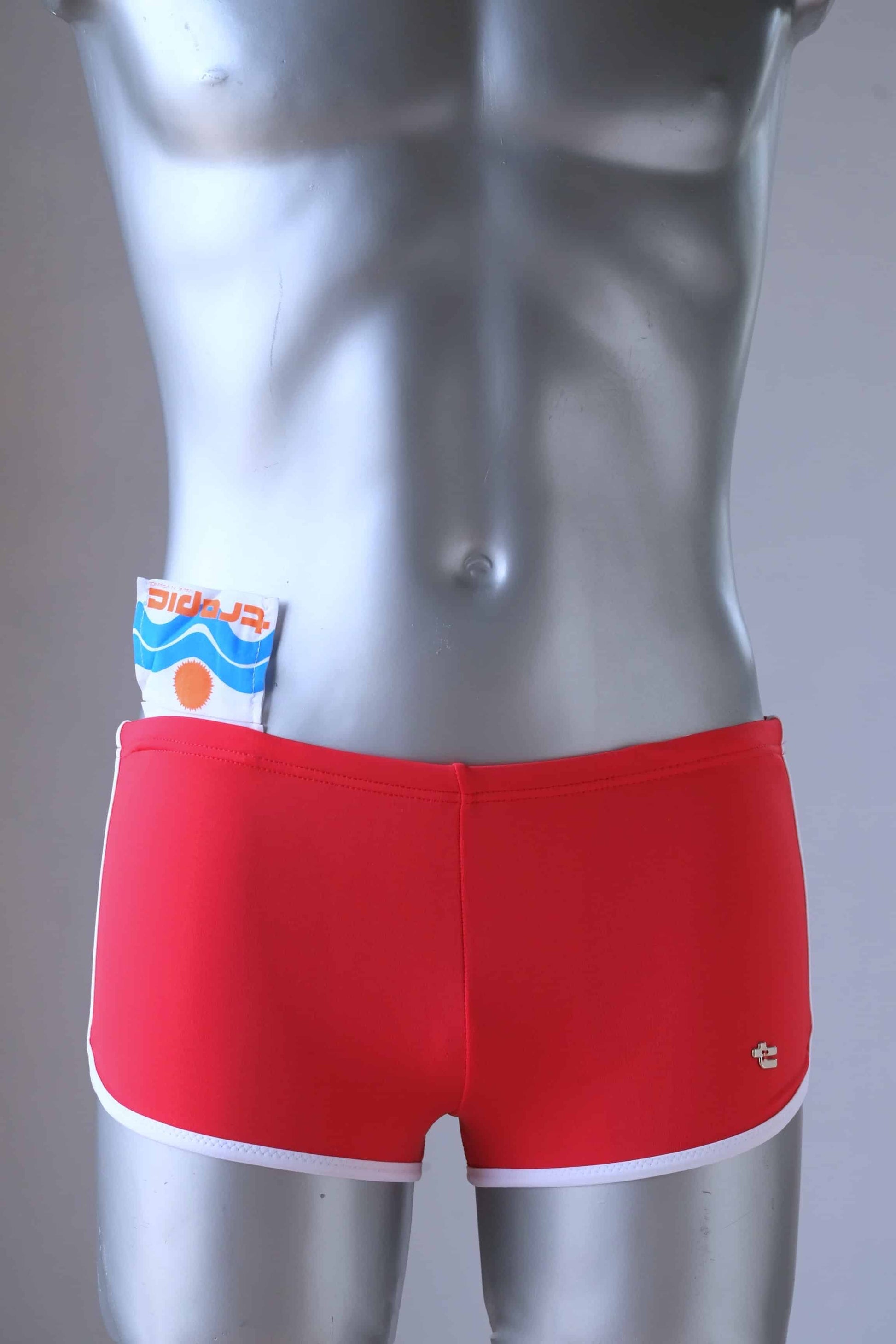 Vintage red swimming briefs on mannequin and showing the internal pocket