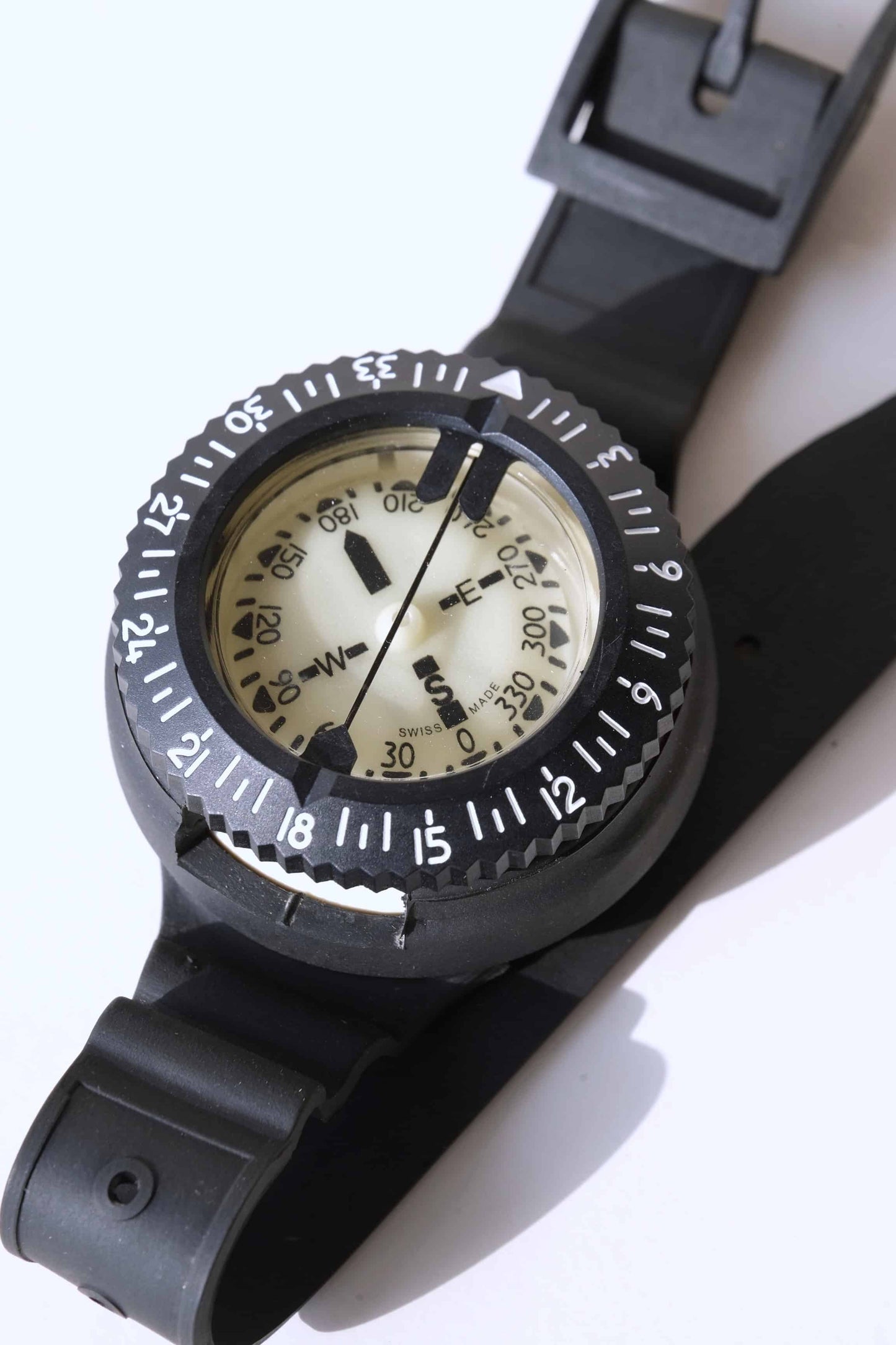 Close view of a Front view of a UWATEC Vintage Oil Filled Submersible Compass displayed with its strap folded, on a white background.