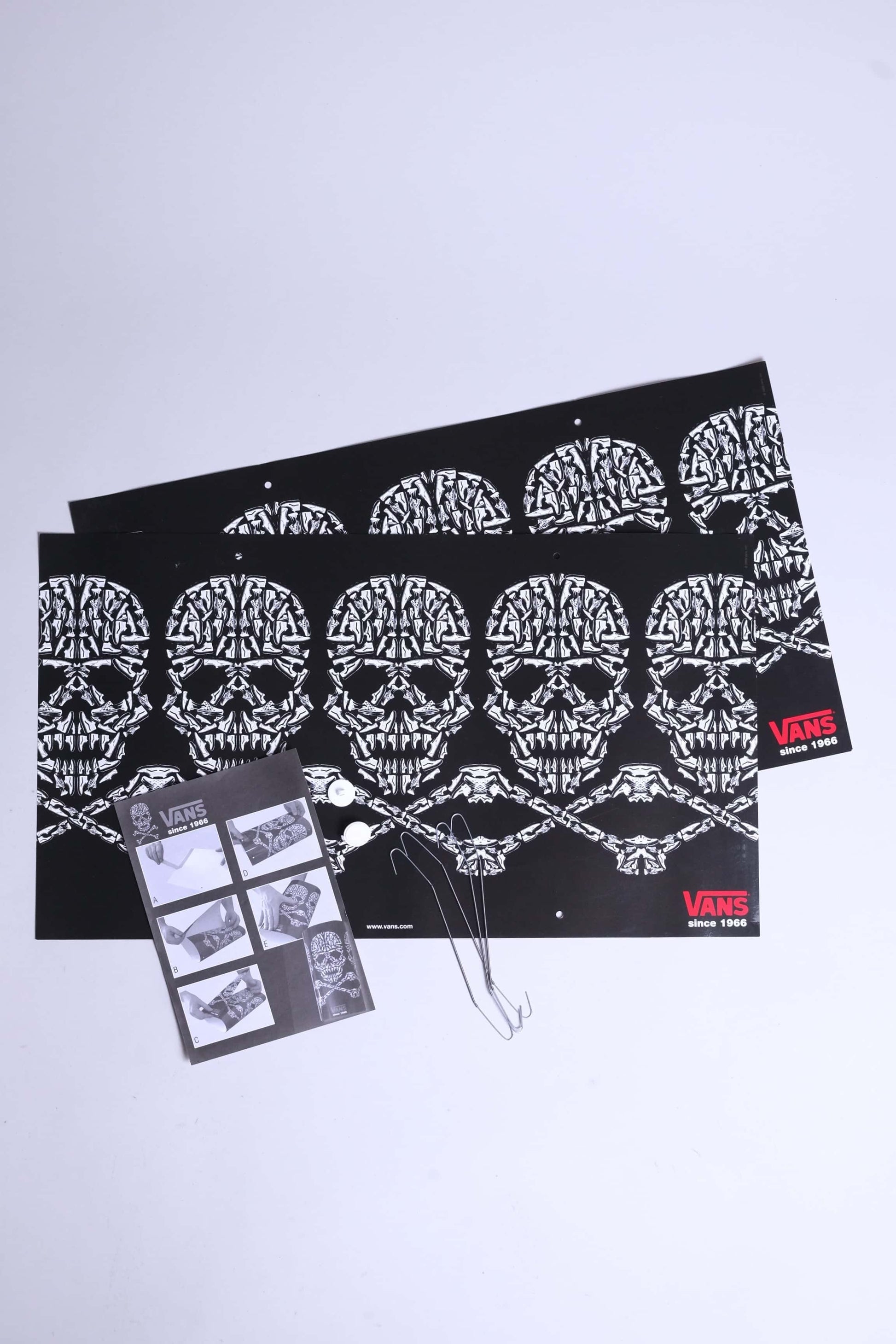 Flat lay of entire VANS skull mobile set including two display sheets, hooks, tacks, and manual.