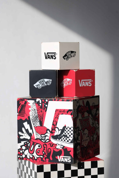 Detailed view of top three VANS nesting display cubes showing light scuffs, logos, and vintage wear on corners.
