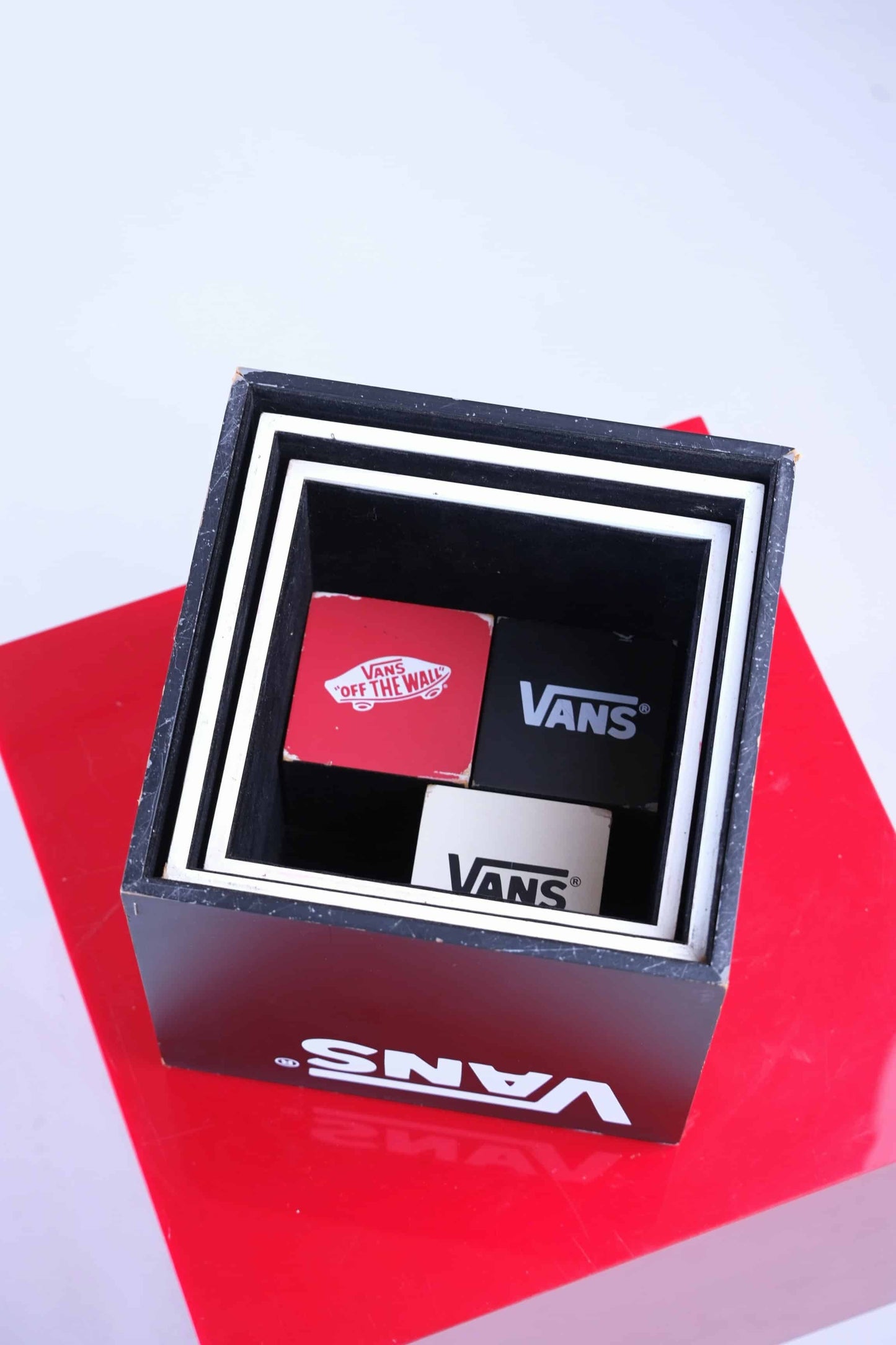 Top-down photo of the VANS display cubes neatly nested inside the largest black cube, showing efficient storage design.