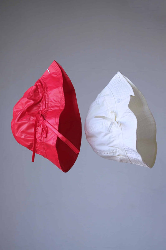 Two VINTAGE Rainproof Bucket Hat, a red one and a white one in front of a grey background