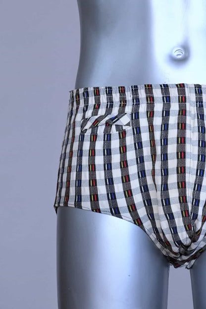 Close view of a vintage late 1950s to early 1960s men's swim brief on a silver mannequin. The brief features a plaid pattern in white, blue, and red, with a small front flap pocket.