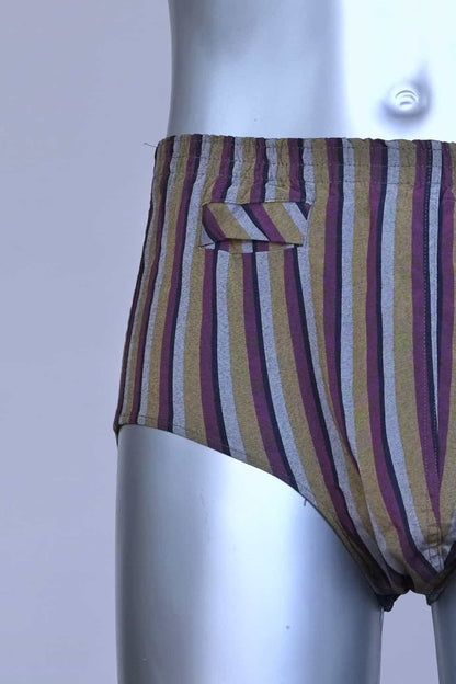 Close view of a vintage late 1950s to early 1960s men's swim brief on a silver mannequin. The brief features vertical stripes in muted brown, grey, and maroon tones, with a small front flap pocket.