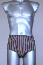 Front view of a vintage late 1950s to early 1960s men's swim brief on a silver mannequin. The brief features vertical stripes in muted brown, grey, and maroon tones, with a small front flap pocket.