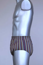 Side view of a vintage late 1950s to early 1960s men's swim brief on a silver mannequin. The brief features vertical stripes in muted brown, grey, and maroon tones, with a small front flap pocket.