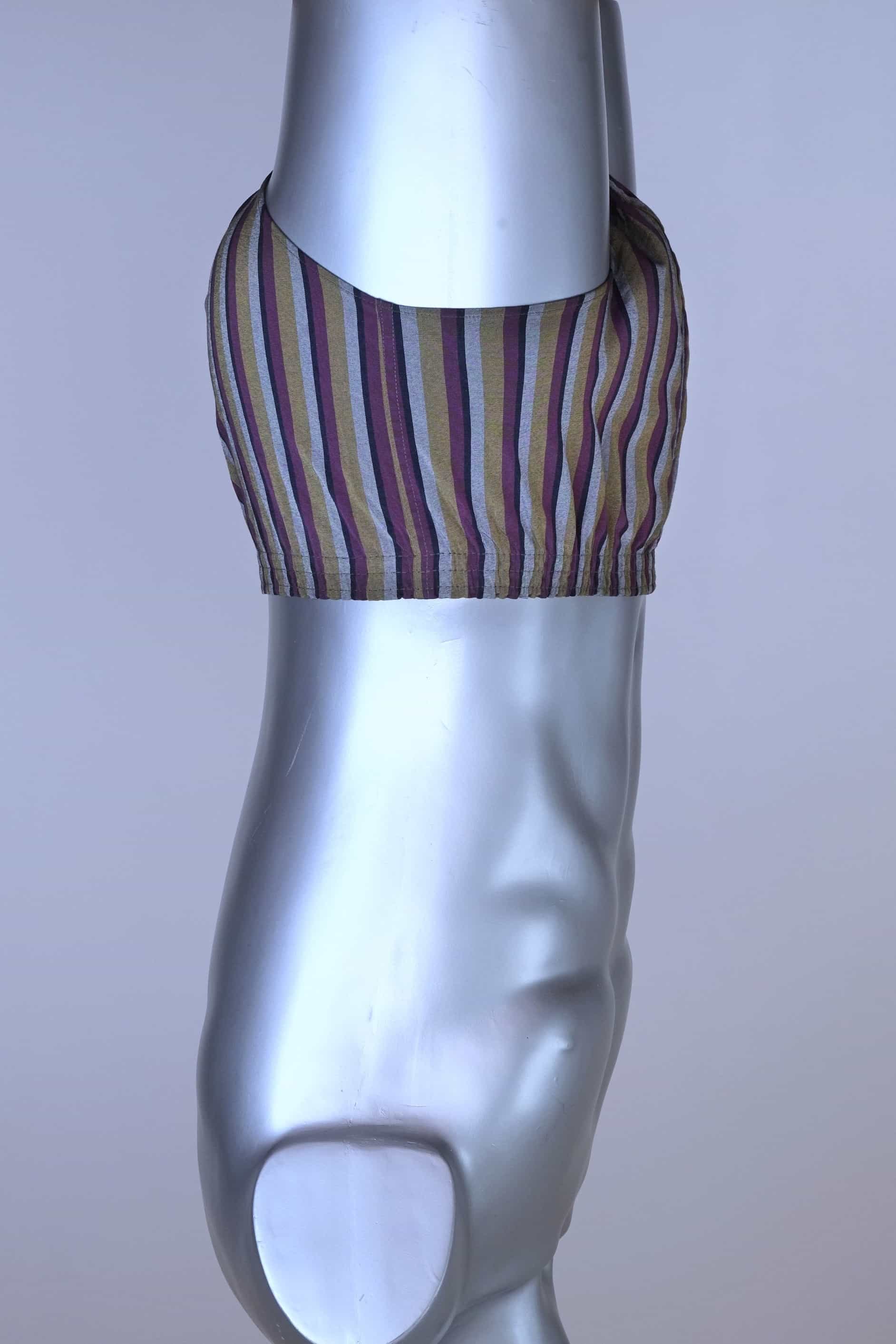 Side view of a vintage late 1950s to early 1960s men's swim brief on a silver mannequin. The brief features vertical stripes in muted brown, grey, and maroon tones, with a small front flap pocket.