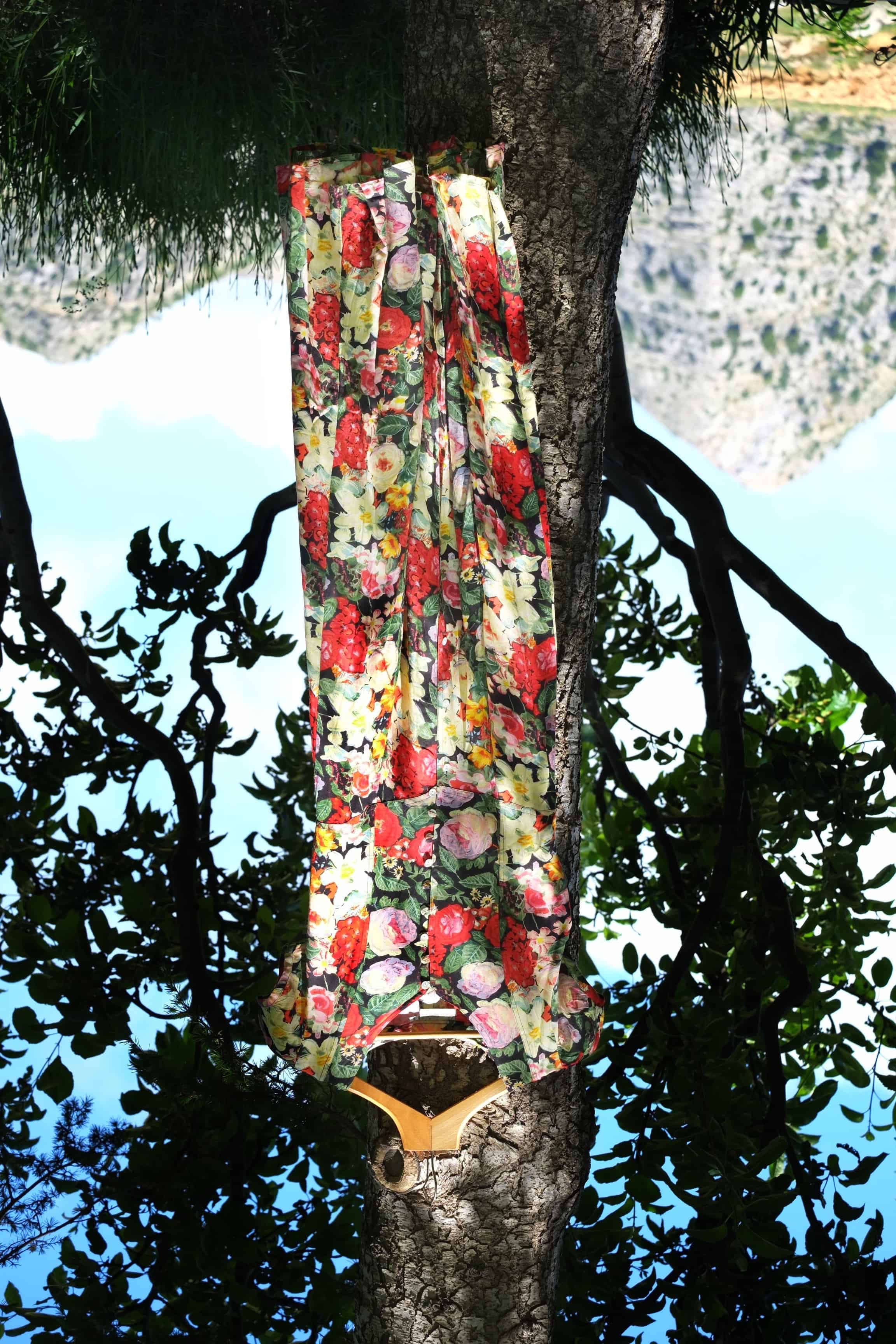 Vintage 90s floral maxi dress hanging on a tree branch outdoors with mountain landscape background