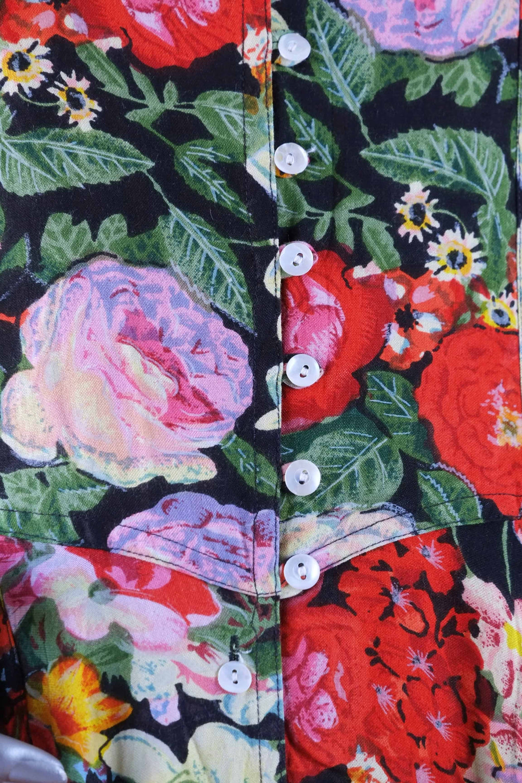Close-up of mother-of-pearl buttons on vintage 90s floral print maxi dress bodice