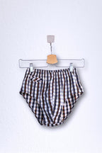 Front view of a vintage late 1950s to early 1960s men's swim brief on a hanger. The brief features a plaid pattern in white, blue, and red, with a small front flap pocket.