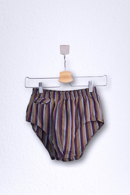 Front view of a vintage late 1950s to early 1960s men's swim brief on a hanger. The brief features vertical stripes in muted brown, grey, and maroon tones, with a small front flap pocket.