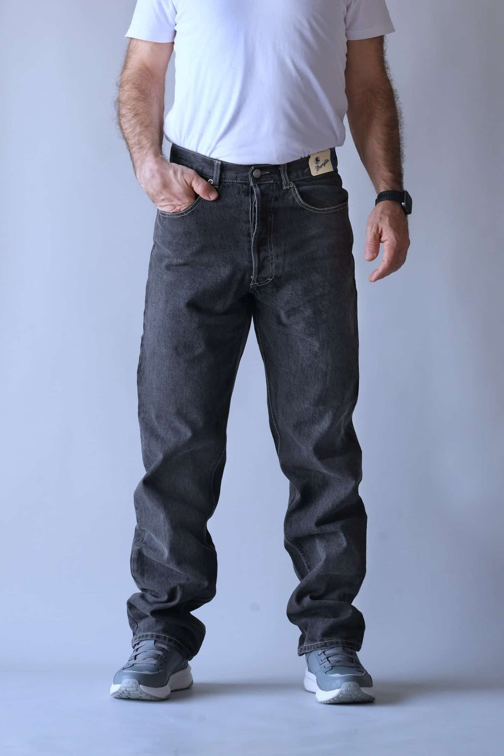 Front view of a person wearing Wrangler black wash straight-leg jeans.