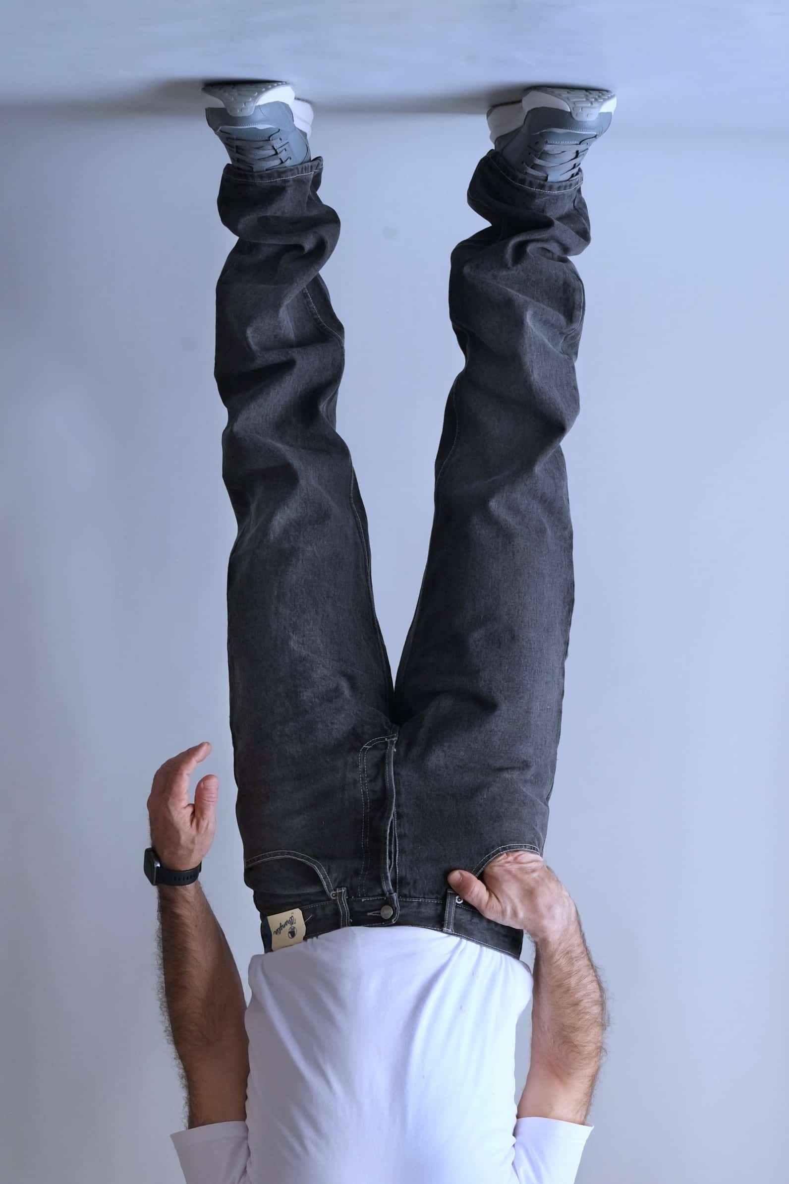 Front view of a person wearing Wrangler black wash straight-leg jeans.