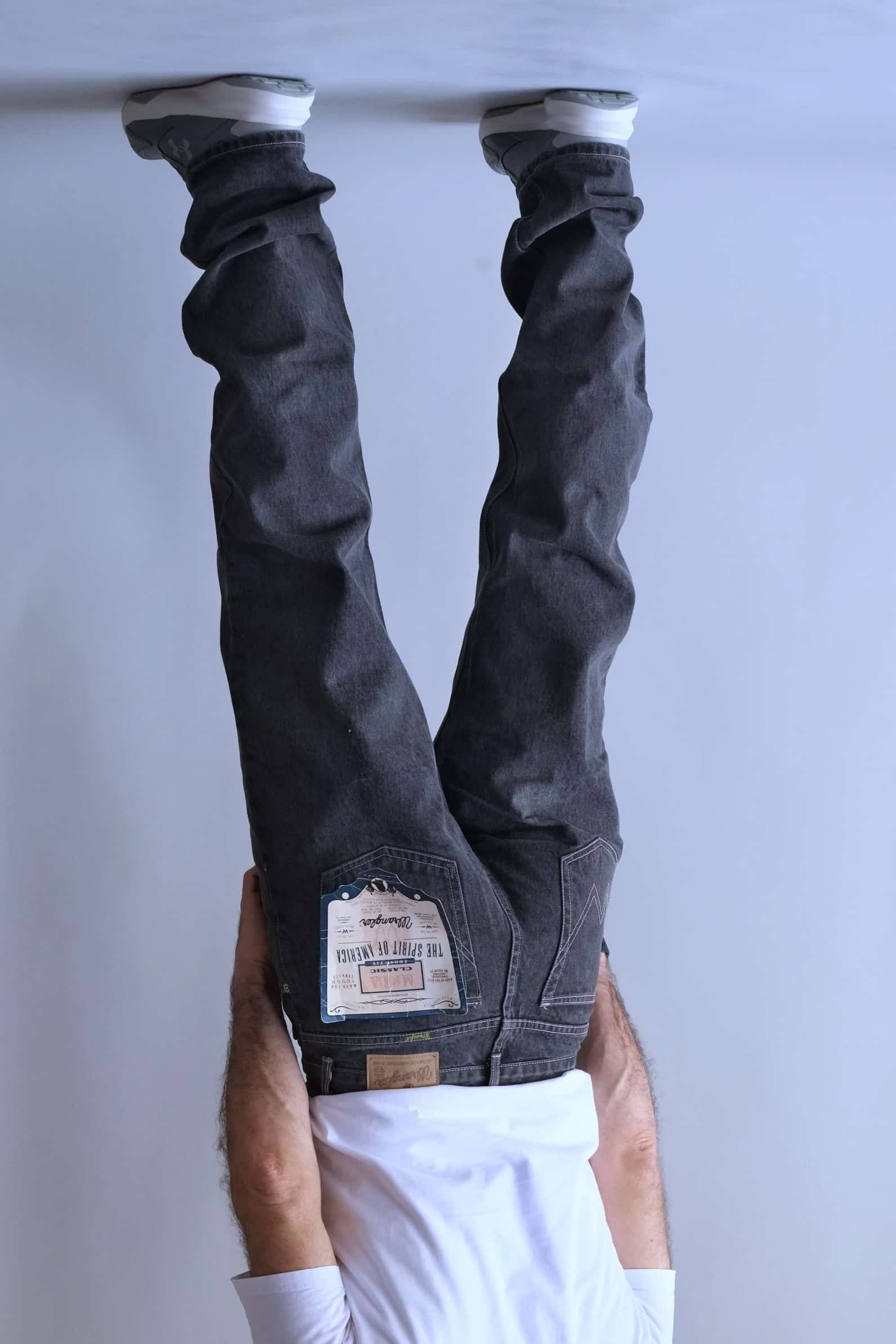 rear view of a person wearing Wrangler black wash straight-leg jeans.
