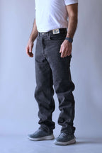 Side-angle view of a person wearing Wrangler black wash straight-leg jeans.