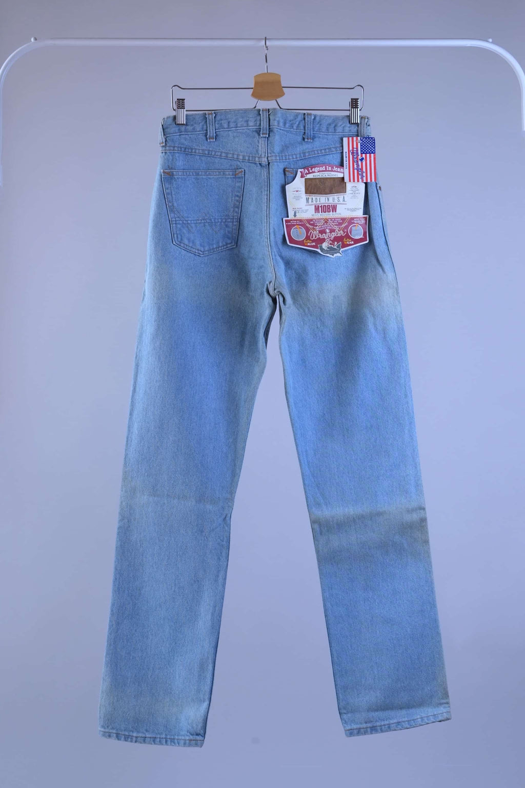 Full back profile of 90s WRANGLER light wash jeans hanging, showing the signature western "W" pocket stitching and straight cut.