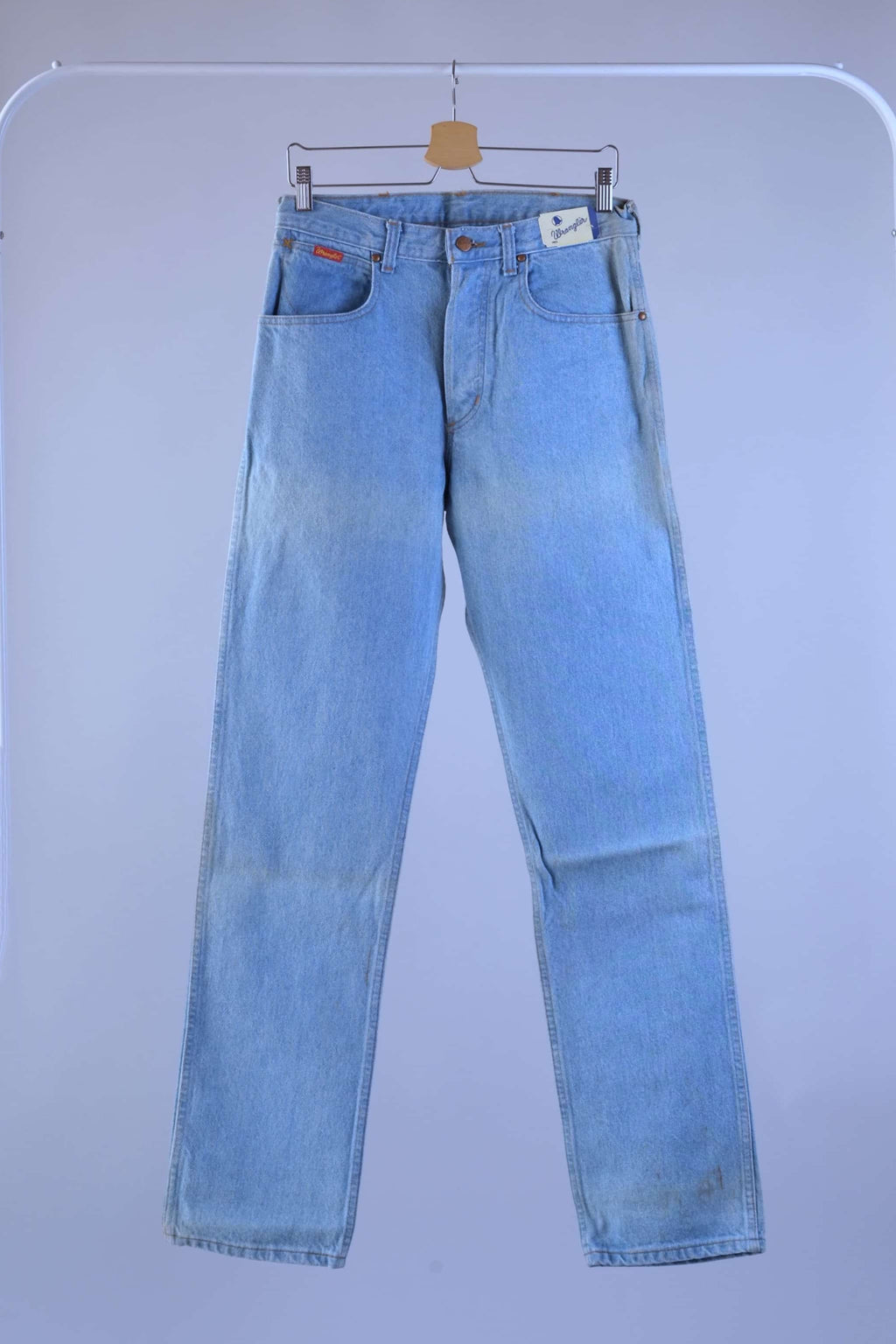 Full front profile of vintage WRANGLER light wash denim jeans, highlighting the straight leg fit and original folded storage fading.