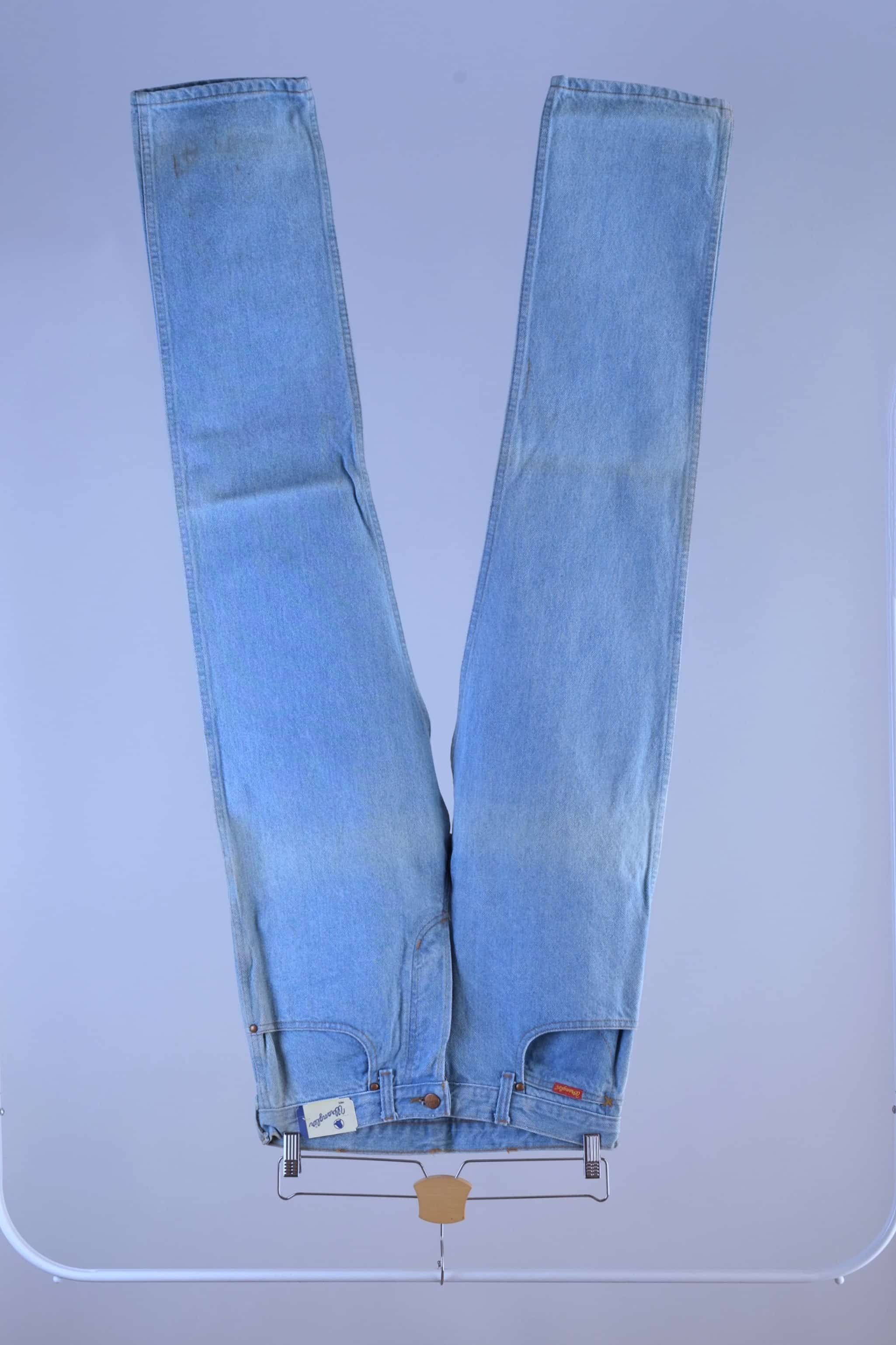 Full front profile of vintage WRANGLER light wash denim jeans, highlighting the straight leg fit and original folded storage fading.