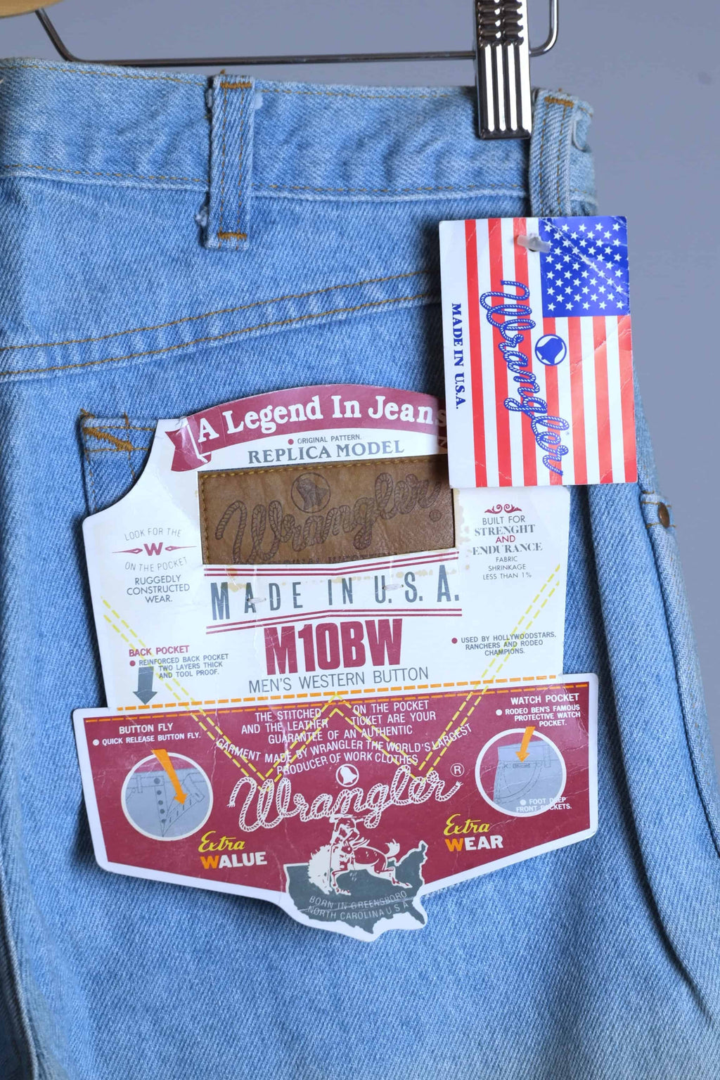 Detailed view of WRANGLER M10BW "A Legend In Jeans" replica model back pocket tag and American flag "Made in U.S.A." branding.