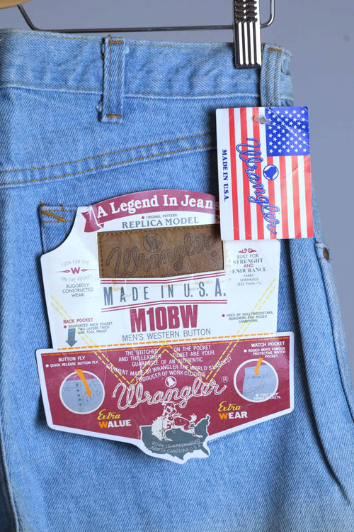 Detailed view of WRANGLER M10BW "A Legend In Jeans" replica model back pocket tag and American flag "Made in U.S.A." branding.