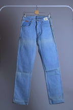 Front full-length view of WRANGLER 90s light wash straight leg jeans hanging on a white rack against a neutral background.