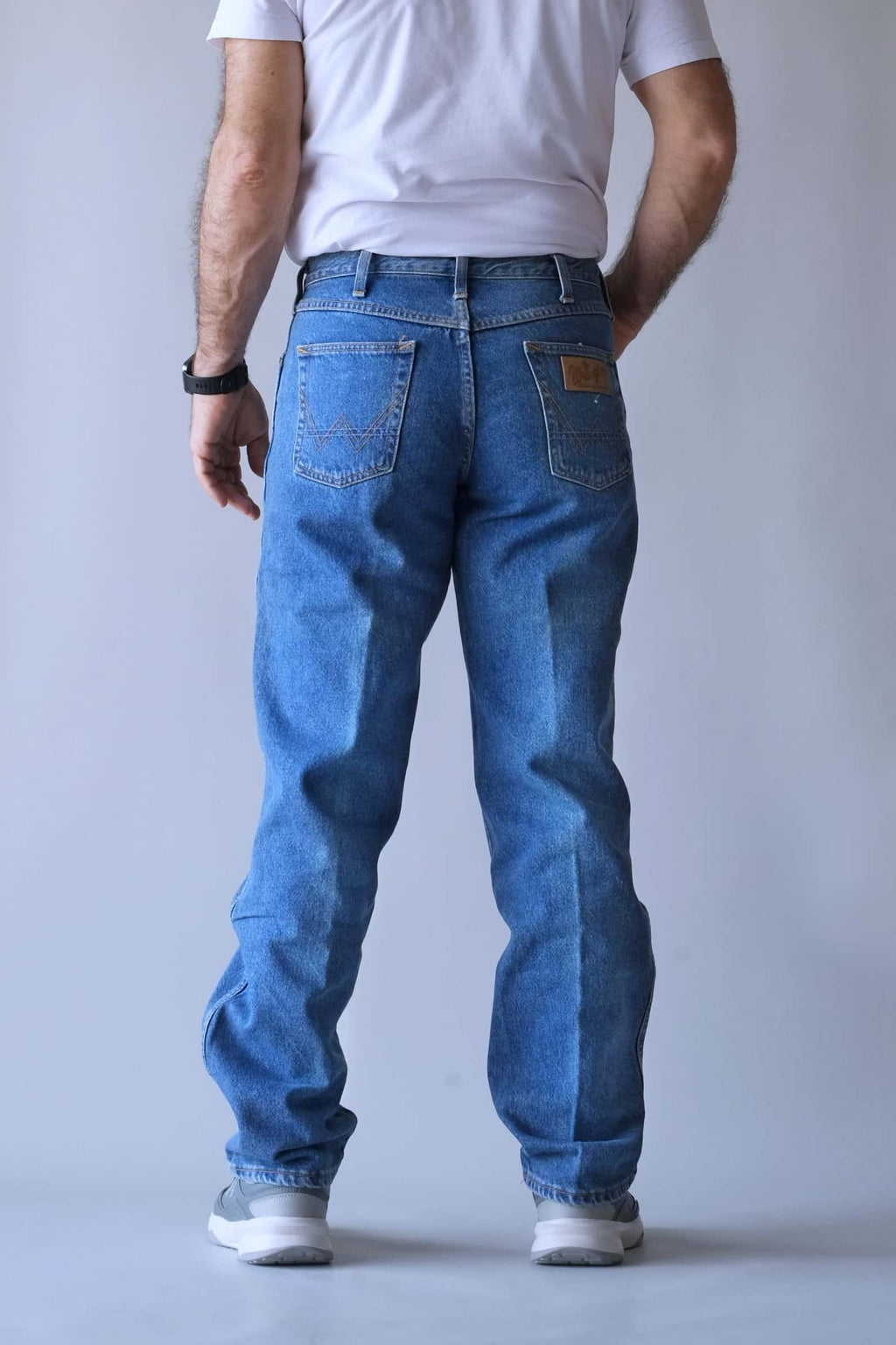 Rear view of Wrangler jeans showing the signature "W" pocket stitching and logo patch.