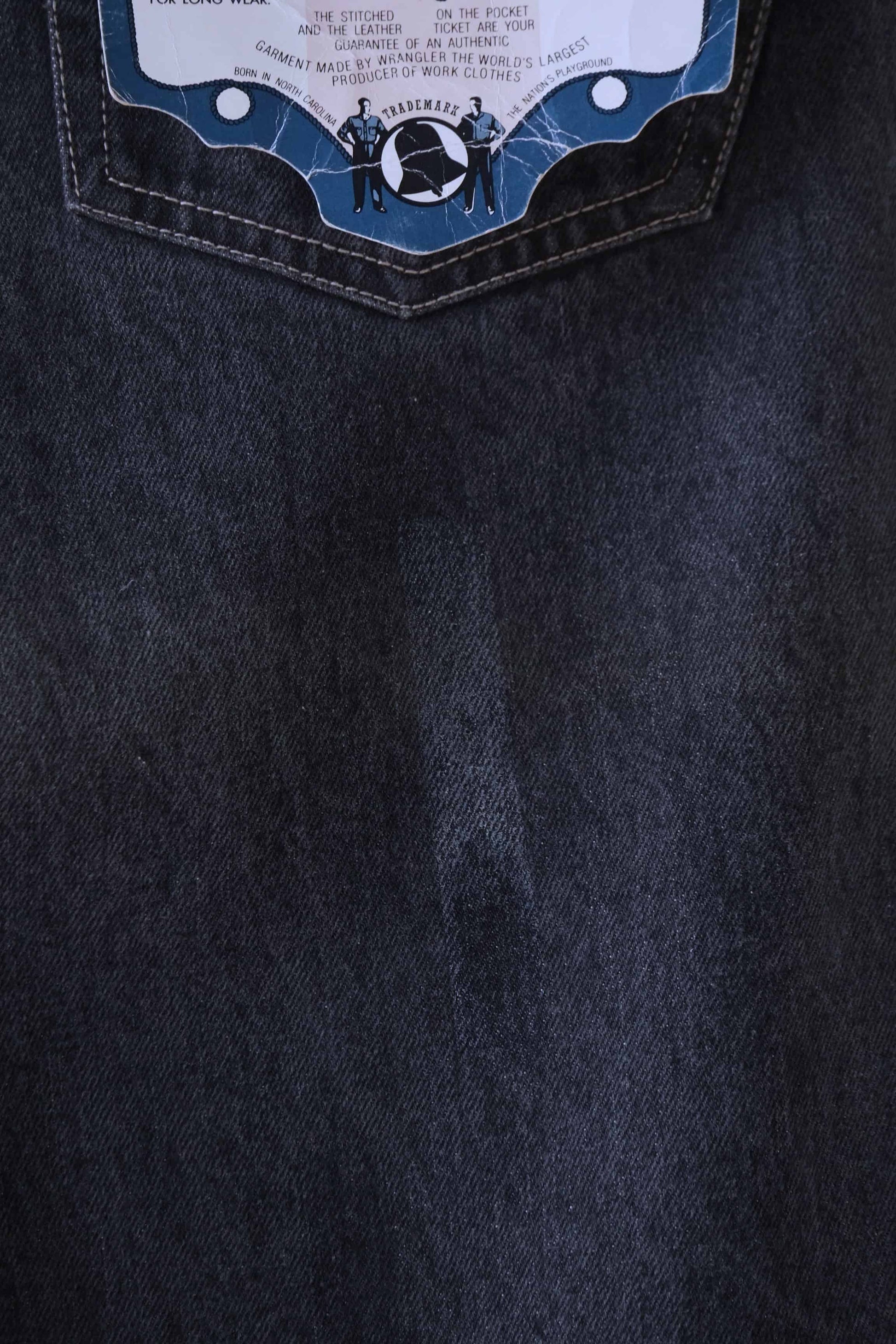 Close view of a discoloration spot on the back of a pair of WRANGLER Vintage 90's Black Wash Jeans