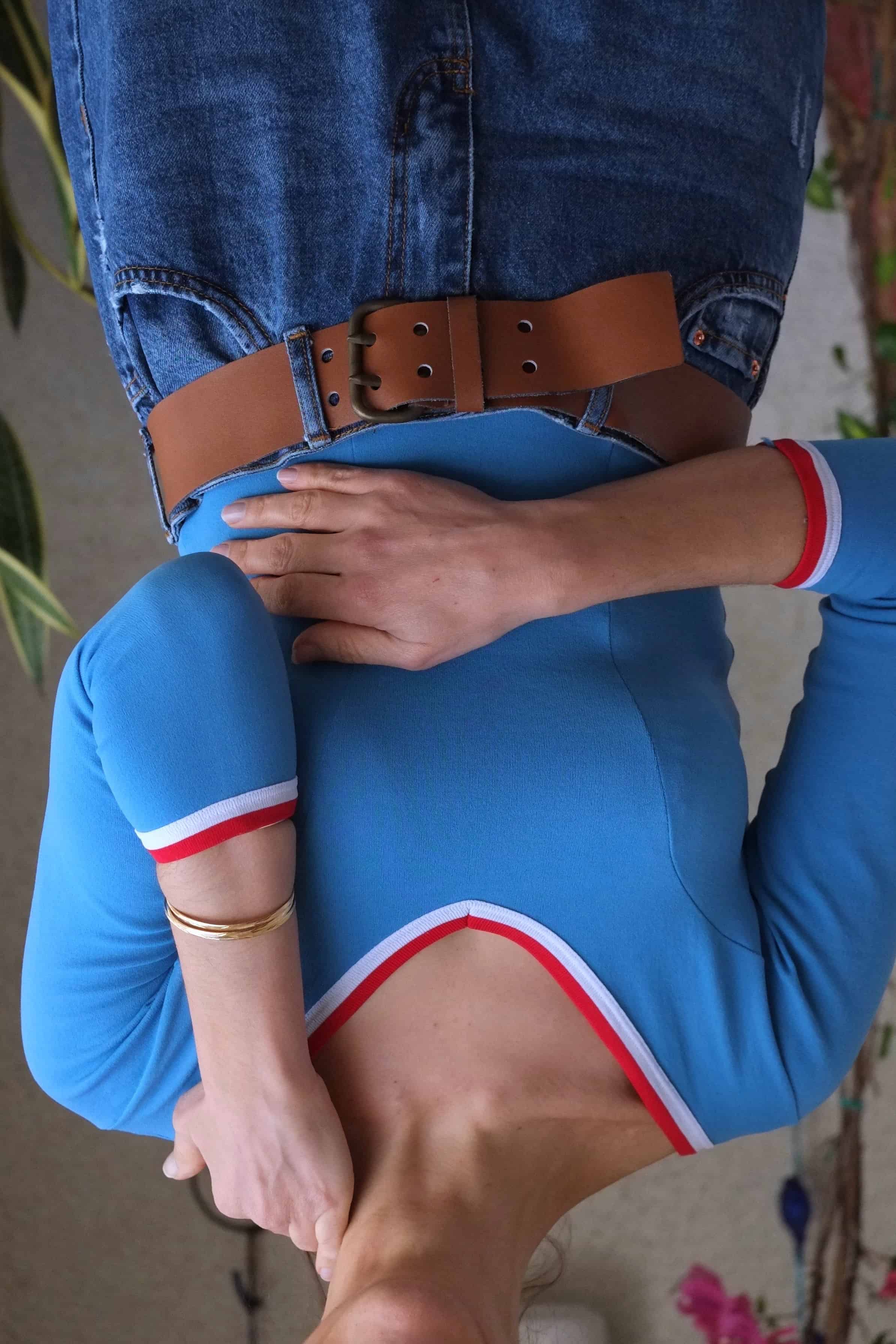 Woman wearing a vintage blue Zofina leotard with a leather belt and denim jeans.