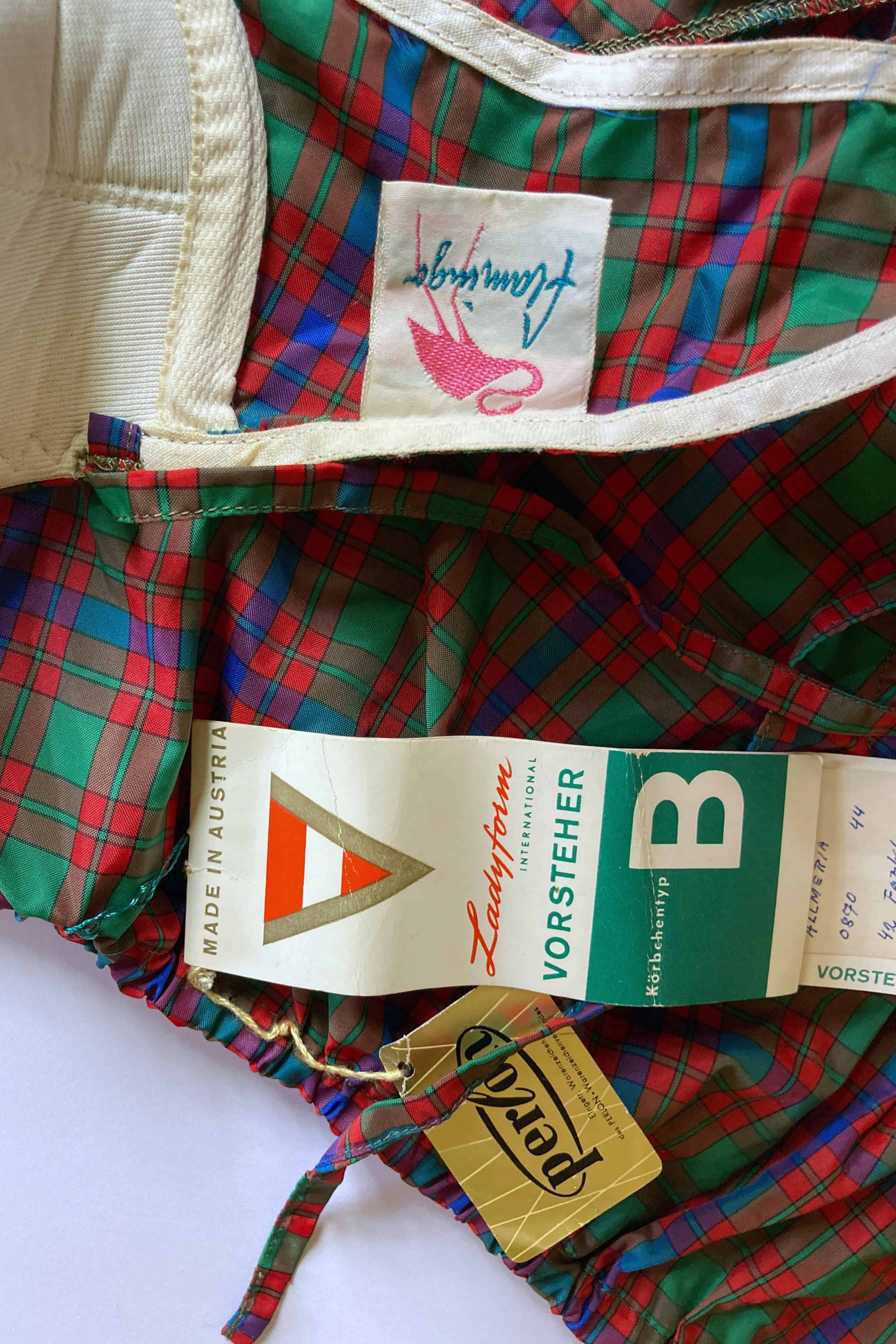 Detail shot of the vintage bikini showing the stitched pink Flamingo woven label alongside original paper Vorsteher and Perlon paper hang tags.