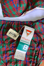 Flat lay close-up of original vintage paper hang tags for Vorsteher Ladyform size B and Perlon attached to tartan plaid bikini bottoms.