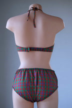 Rear view of a vintage tartan plaid two-piece bikini set on a mannequin, showing the back hook strap, tied halter neck, and high-waisted briefs.