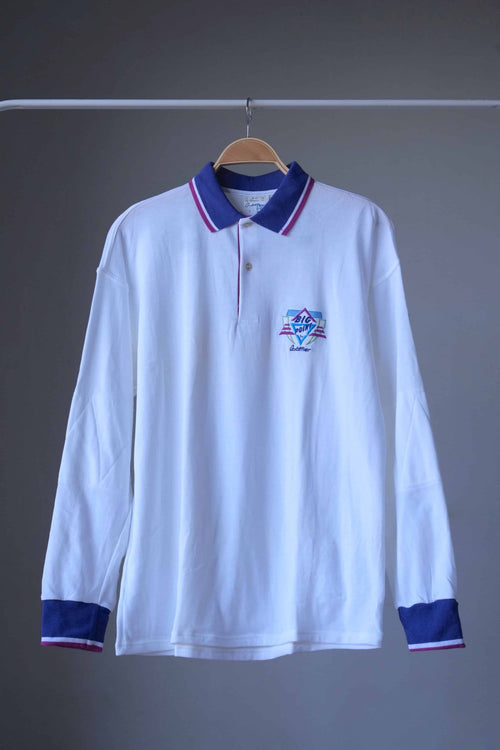 Löffler 90s men’s long-sleeve tennis polo in white with royal purple collar and cuffs and magenta tipping, front view on hanger