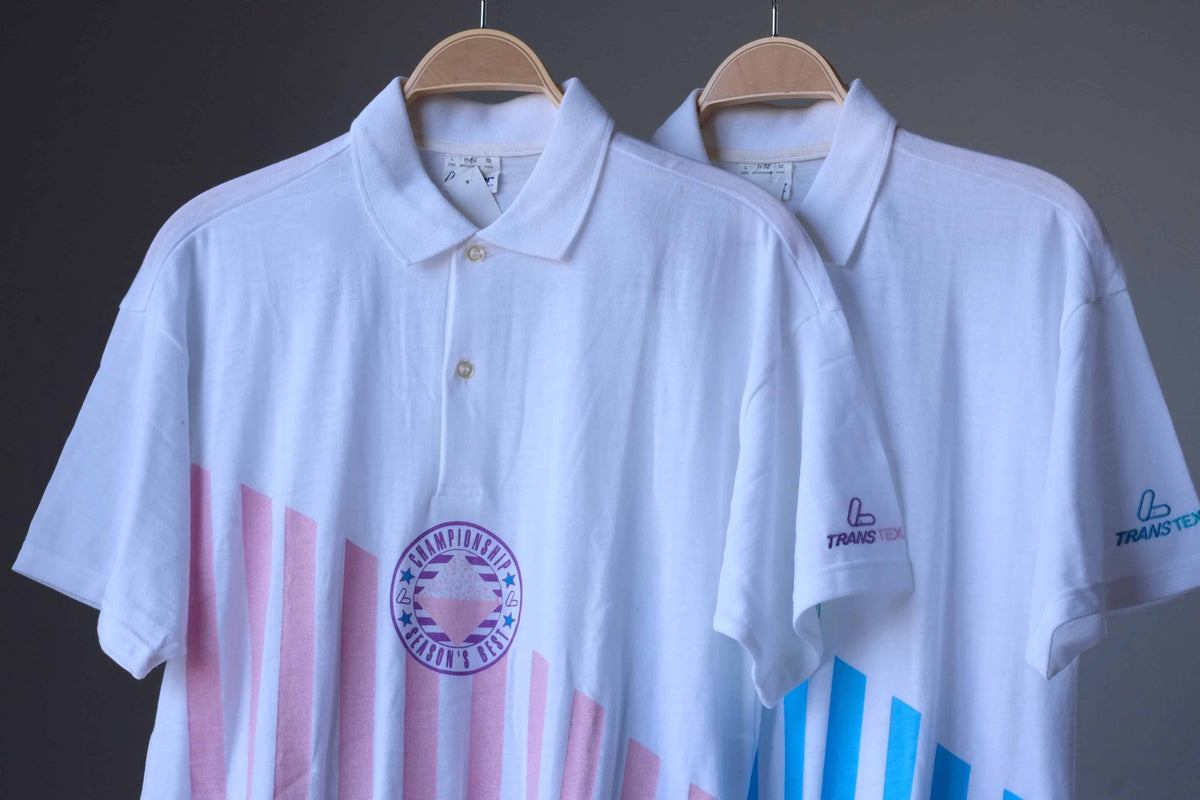 Two Löffler 90s men’s tennis polos in white, pink and sky blue vertical stripes, Championship Season’s Best badge and embroidered Transtex sleeve logos