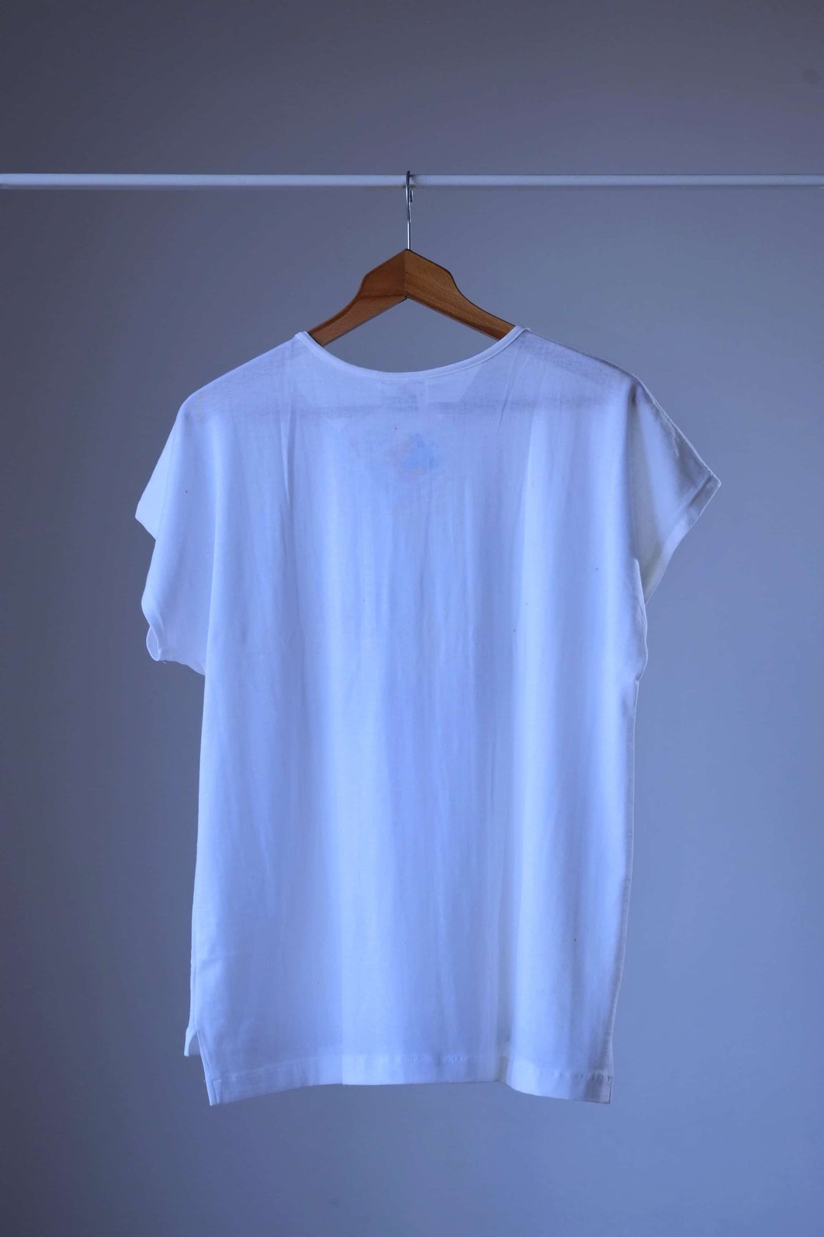 Back view of white Löffler 90s women’s henley top with cap sleeves, round neckline and side vents, plain back with no print